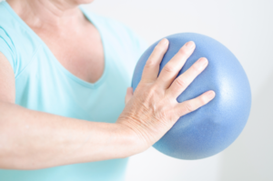 Frau macht Sport mit einem Pilatesball