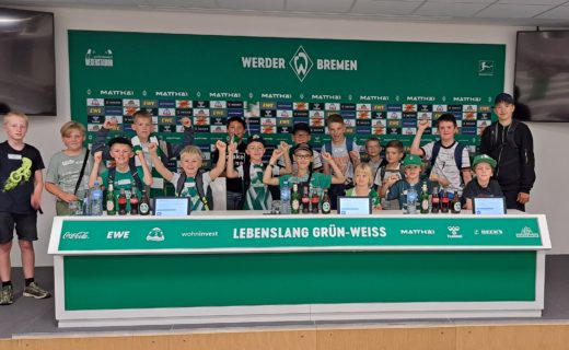 <p>Eine Gruppe der Teweler Ferienpassaktion bei der Stadionführung im Pressekonferenz-Raum des Bremer Weserstadions</p>