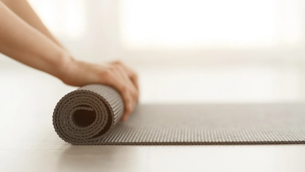 Yogamatte wird zusammengerollt
